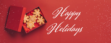 Christmas gingerbread cookies red box red festive background. Festive banner phrase Happy Holidaysの写真素材