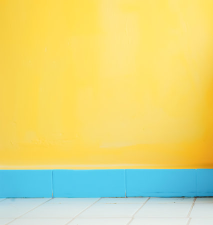 Bright yellow painted wall with blue baseboard. Minimalistic textured background, copy spaceの素材