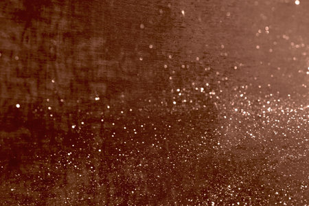Glittering abstract texture with brown background and sparkling particlesの写真素材