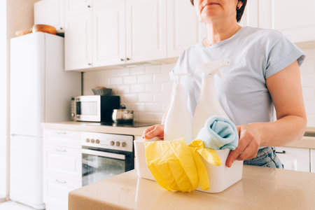 Mature woman in kitchen with cleaning products, cleaning concept, cleaning servicesの写真素材