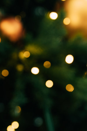 Abstract holiday lights bokeh with soft green and gold tones, Christmas abstract blur background, sparkling garlands and lightsの写真素材