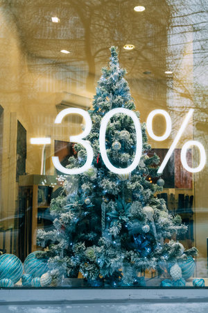 Festive christmas tree display with holiday discount in store windowの写真素材