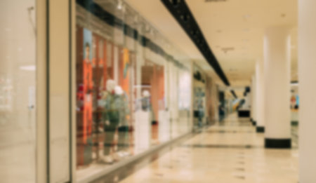 Blurred empty shopping mall with display windows and bright interior lightingの写真素材