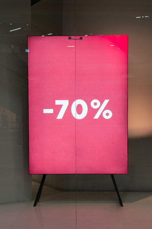 Bold red sale sign with 70 percent discount displayed at storefrontの写真素材