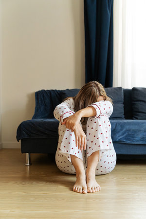 Woman sitting alone on floor feeling despair and grief. Womens mental health, frustration, psychological state of mindの写真素材