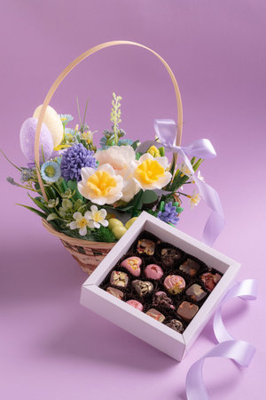 Easter basket with flowers and chocolate truffles for spring giftの写真素材