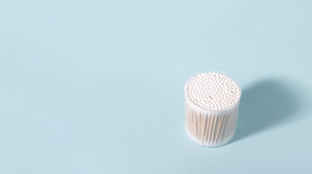 White cotton swabs with wooden sticks for hygiene on blue background