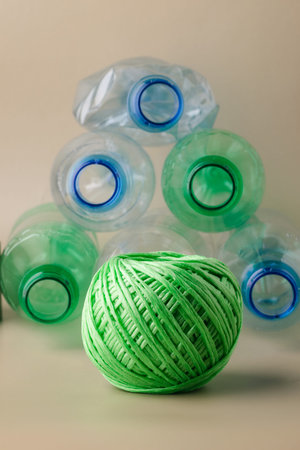Green yarn ball and plastic bottles representing recycling