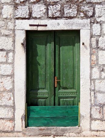 Old green painted door with stone frameの写真素材