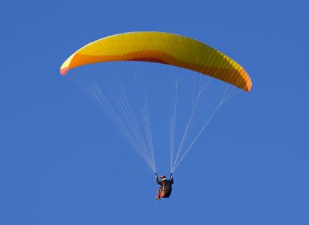 Solo paraglider under cloudless blue skyの写真素材