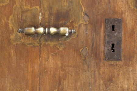 Worn out old wooden door with brass handleの写真素材