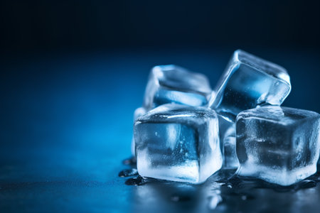 Ice cubes on blue background. Shallow depth of field. Toned.の素材