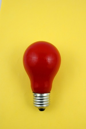 red lightbulb isolated on yellow background closeupの写真素材