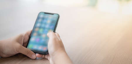 Female hand holding smartphone for find something on internet or shopping online while sitting one...