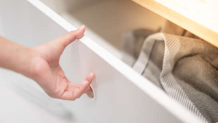 Female hand open stainless steel drawer with the grey t-shirt put on the drawer, For the lifestyle concept.の写真素材