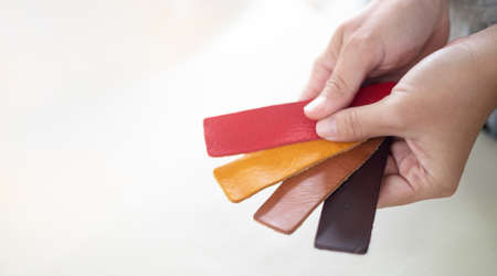 Female hand holding multicolor leather prepare for pattern handmade as leather tag or part of the bag with the standard size.の写真素材