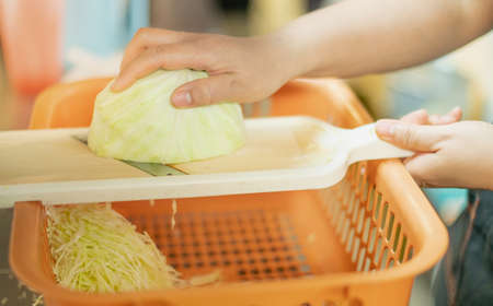 Chef slide cauliflower preparing raw material for cooking to the customer in the kitchenの写真素材