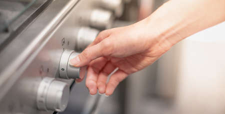 Close up female hand Opening Or Closing modern electric oven prepare to cook in the modern kitchen.の写真素材