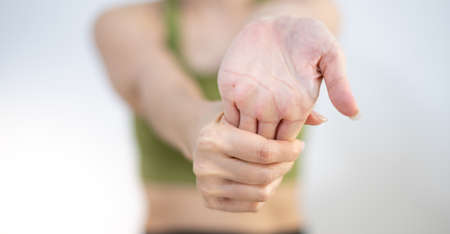 Woman stretching their arms to relax and be flexible while doing exercise in their home.の写真素材