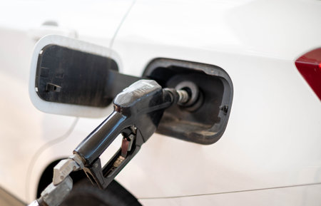The nozzle fuel fill oil into car tank at pump gas station, For the concept transportation power business technology conceptの写真素材