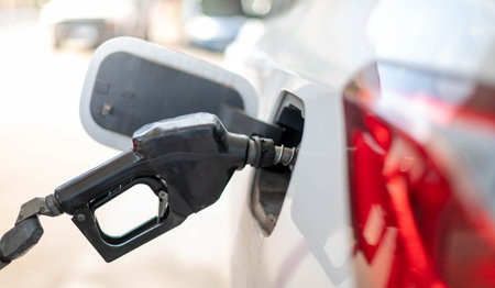 The nozzle fuel fill oil into car tank at pump gas station, For the concept transportation power business technology conceptの写真素材