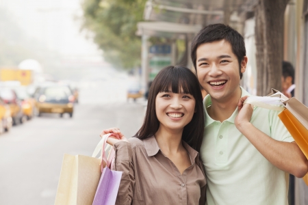 Portrait of smiling young couple at the bus stop, Beijing, Chinaの写真素材
