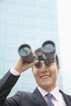 Smiling Businessman Using Binoculars, Reflectionの写真素材