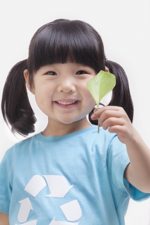 Little girl holding leaf, close up studio shotの写真素材