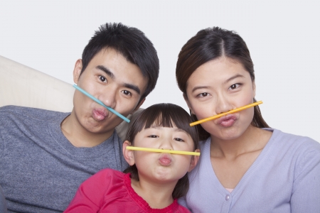 Portrait of family making a face with drinking strawsの写真素材