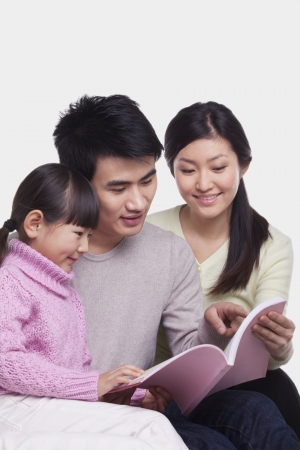 Family reading on the sofa, studio shotの写真素材
