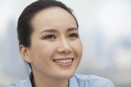 Close-up of smiling young woman looking upの写真素材