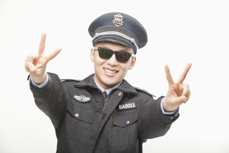 Police Officer Giving Peace Sign, Studio Shotの写真素材