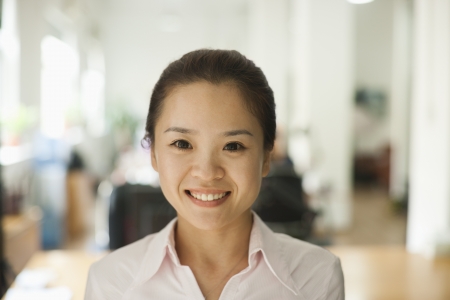 Young woman smiling in the office, portraitの写真素材