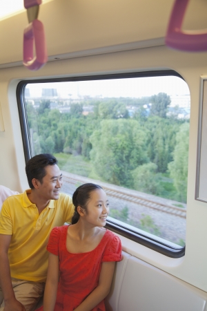 Father and daughter looking through the window in the subway の写真素材