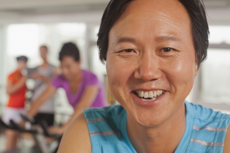 Man smiling and exercising on the exercise bike の写真素材