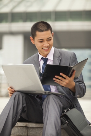 Young businessman working outdoorの写真素材