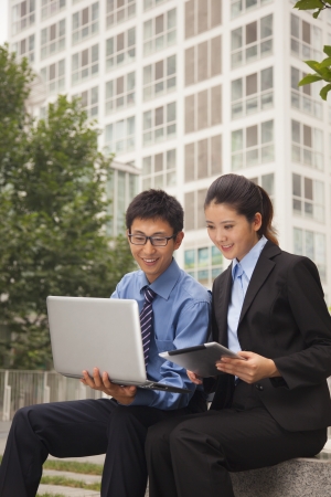 Businessman and businesswoman working outdoorsの写真素材