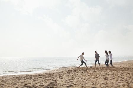 Young Friends Playing Soccer on the Beachの写真素材
