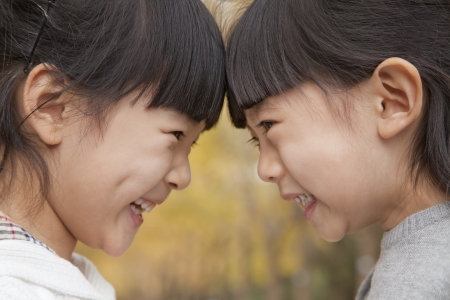 Sisters head to head in parkの写真素材