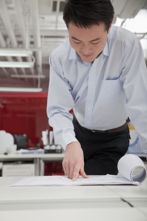 Businessman analyzing architect project in the officeの写真素材
