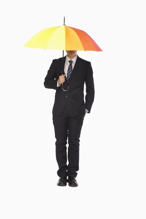 Businessman with hidden face under umbrellaの写真素材