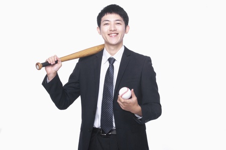Businessman smiling with bat and baseballの写真素材