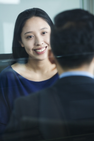 Two co-workers talking in officeの写真素材