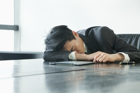 Businessman sleeping in office roomの写真素材