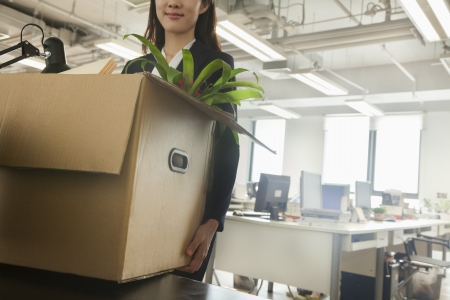 Young businesswoman moving box with office suppliesの素材