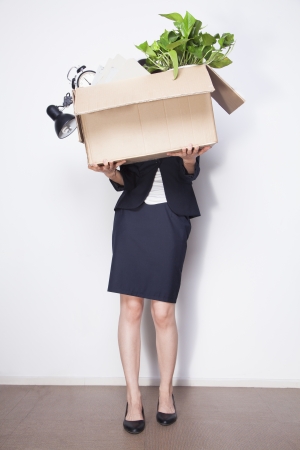 Young Businesswoman holding box of office itemsの写真素材