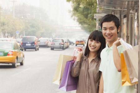 Portrait of smiling young couple at the bus stop, Beijing, Chinaの写真素材