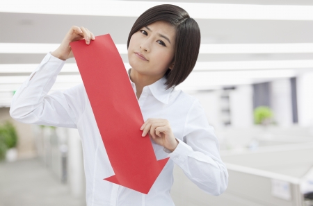 Young Woman Holding Arrow Sign Paper Cutの写真素材