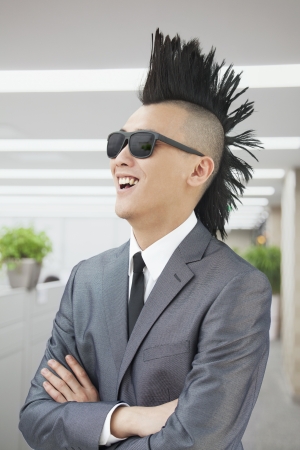 Well-dressed young man with Mohawk and sunglasses smilingの写真素材