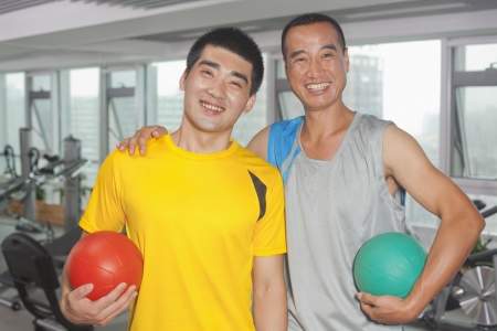 Two men holding balls in the gymの写真素材